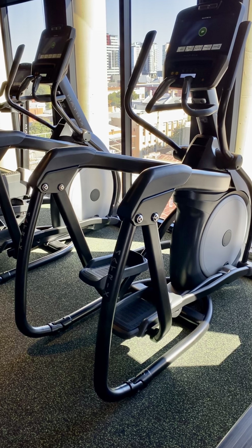 Cross-trainers beside large windows