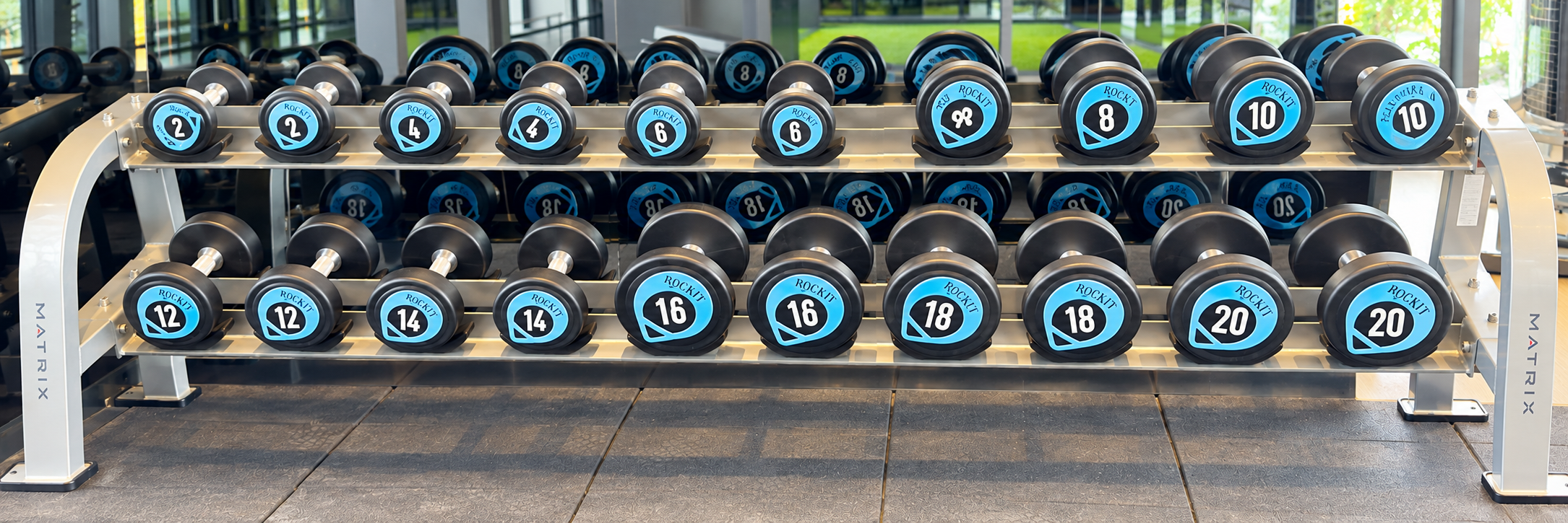 Wide dumbbell rack in a bright modern gym
