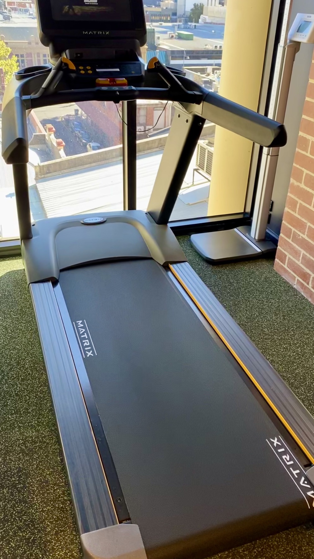 Treadmill beside a city-facing window